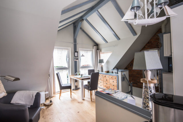 Foto Ryan Baugestaltung Appartmenthaus Lueneburg Wohnzimmer mit Holzgiebel, großen Fenstern und Sitzgelegenheit