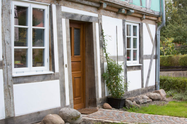 Foto Ryan Baugestaltung Fachwerkhaus Goettingen Eingangstür aus Holz und grüner Vorgarten