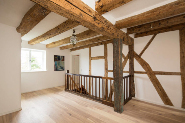 Foto Ryan Baugestaltung Fachwerkhaus Goettingen Raum mit Holzbalken und offener Holtreppe